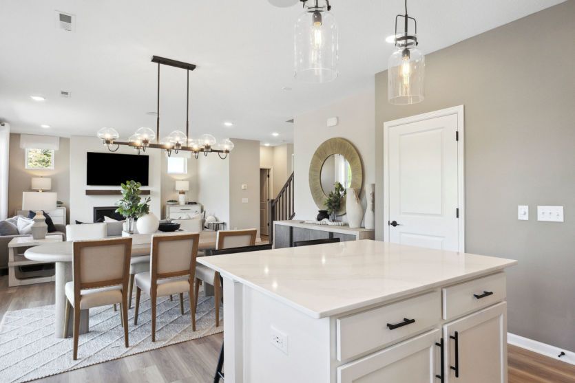 Standing in the kitchen, looking into the dining and gathering rooms beyond