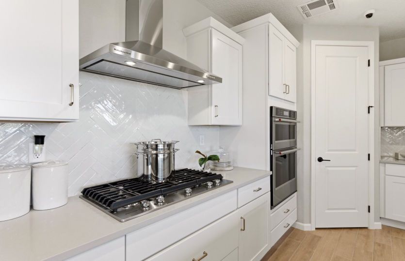 Built-in black stainless Kitchenaid® appliances with range, microwave, and gas cooktop with vent hoo