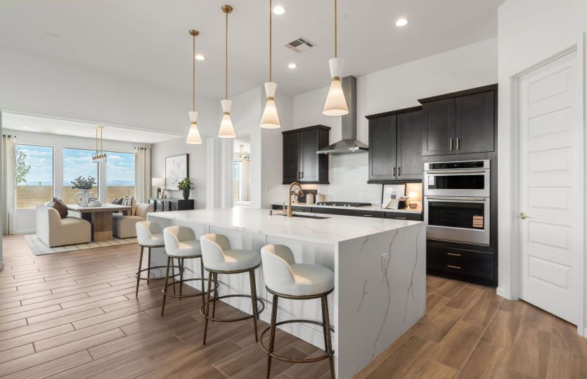 Extended upper cabinets, designer pendant lights, and built-in stainles-steel appliances show off th