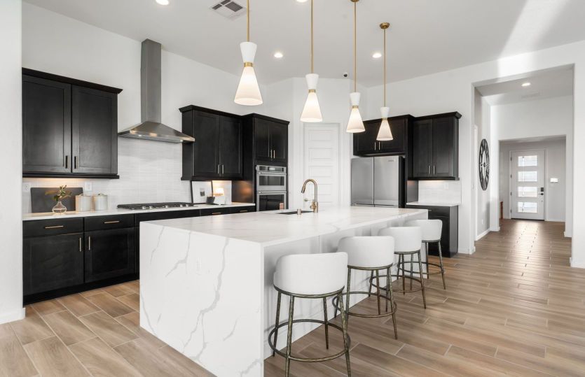 Large kitchen island features a built-in bar overlooking an open floor plan.