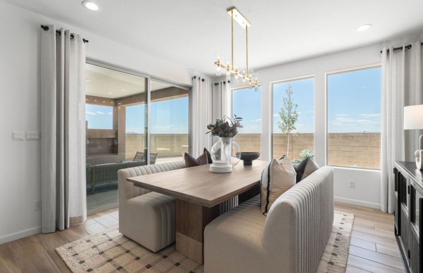 Overhead accent lighting fixtures, large windows, and a sliding glass door accent provide modern bea