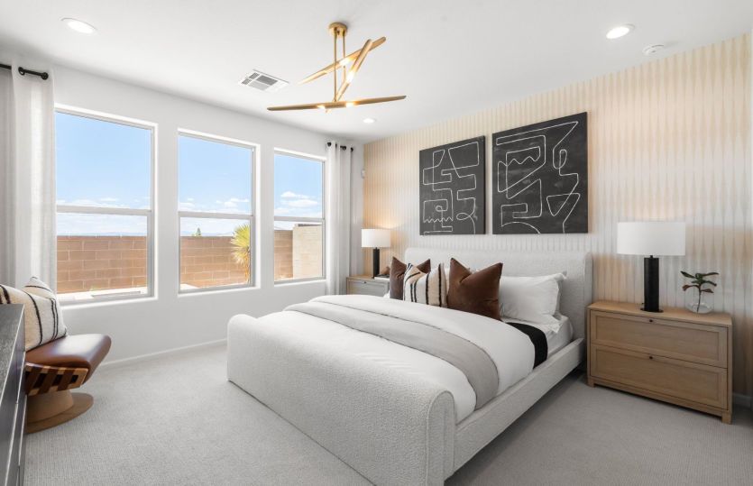 Large windows, an accent wall, and accent lighting fixtures amplify the spacious owner's suite.