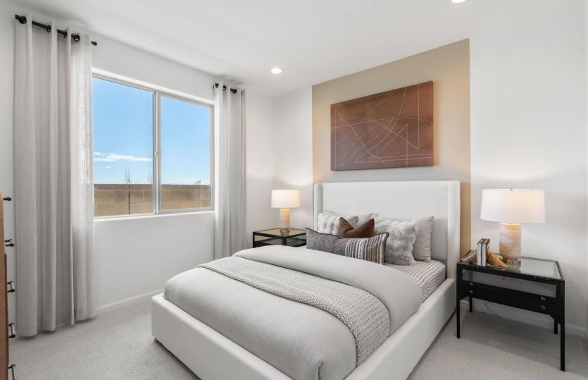 Second bedroom with painted accent wall and large window.