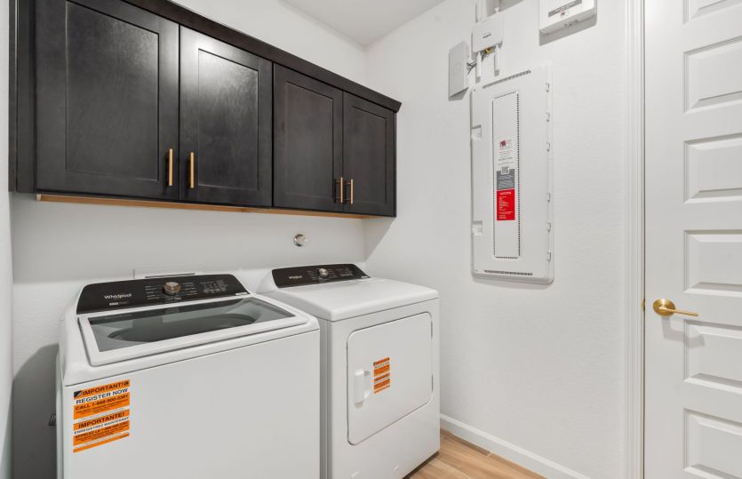 The laundry room boasts additional storage space.