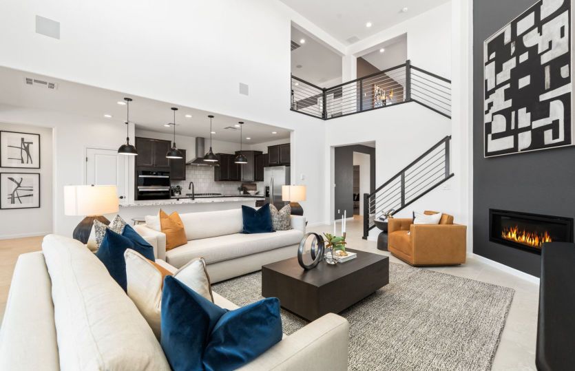 Gathering room and corner fireplace with large, bright windows plus elegant stair railing to the sec