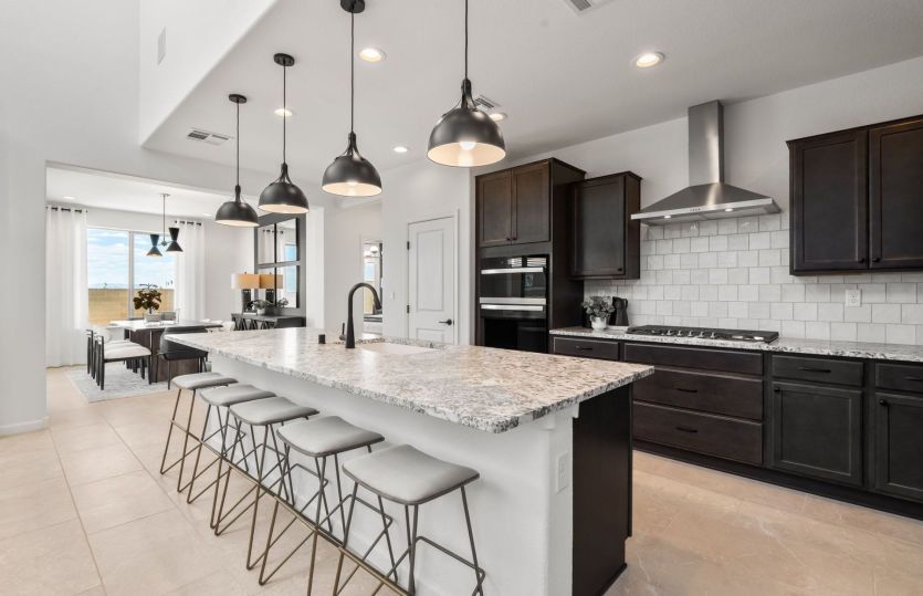 Kitchen include large island, stainless-steel appliances, and extended cabinetry.