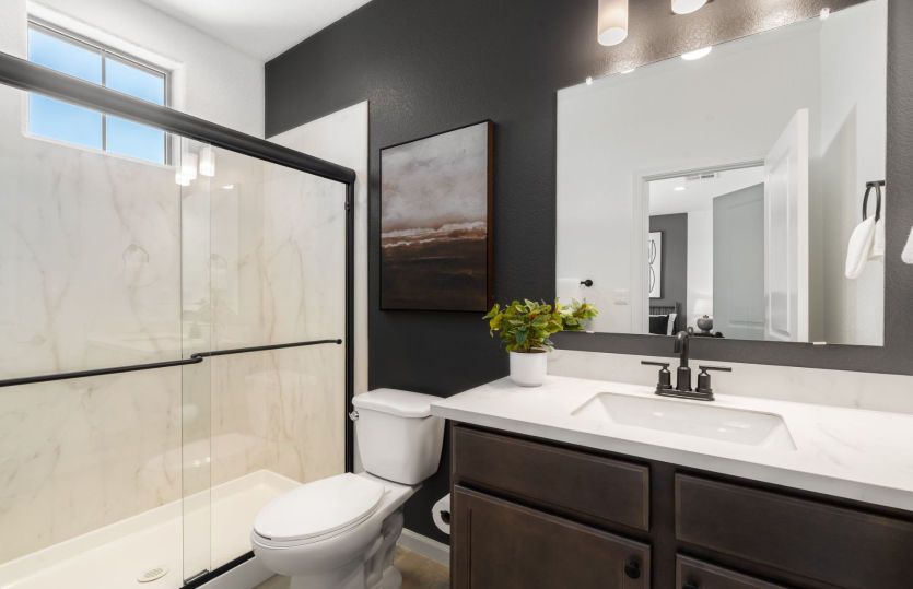 Downstairs guest bath featuring beautiful countertops and a shower/tub combo.