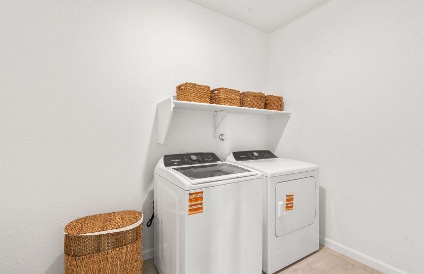 Laundry room with shelf for additional storage.