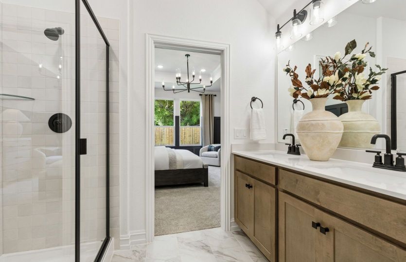 Owner's private bath with tile-surround shower and double vanity *model representation