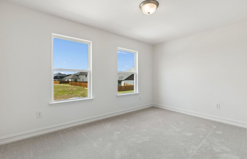 Spacious secondary bedroom with large windows *model representation