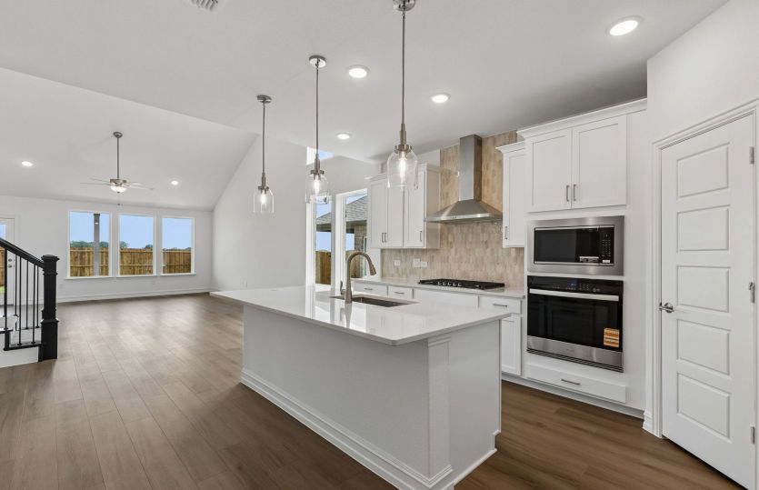 Beautiful pendent lighting in kitchen overlooking gathering room