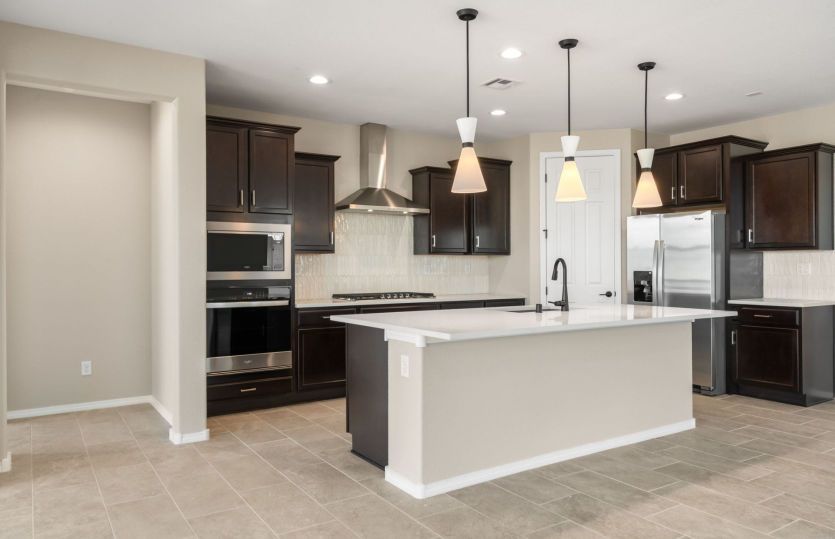 Designer kitchen featuring rich cabinetry and stainless-steel appliances
