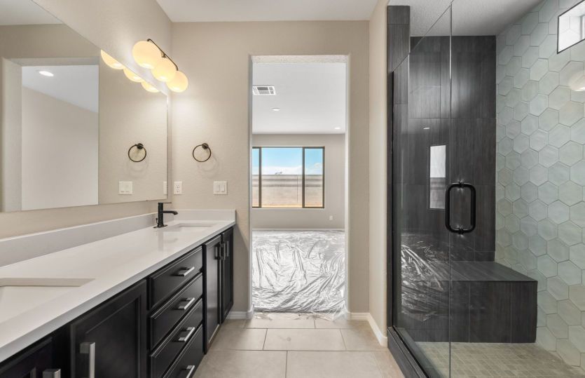 Luxurious owner's bath with a walk-in shower, dual vanities, and premium finishes