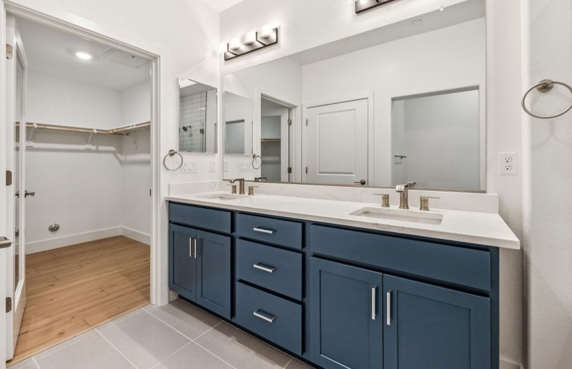 Primary bathroom with dual vanity and walk-in closet access