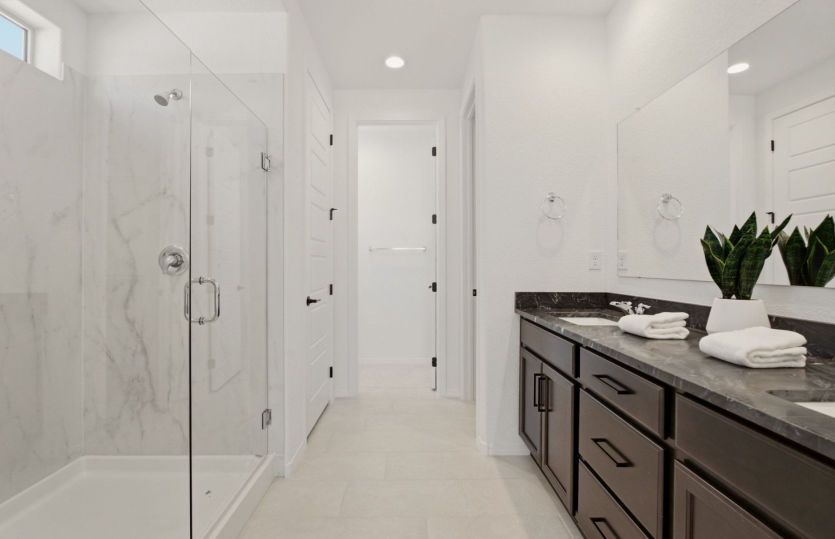 Spa-inspired owner's bath with dual vanities and abundant storage