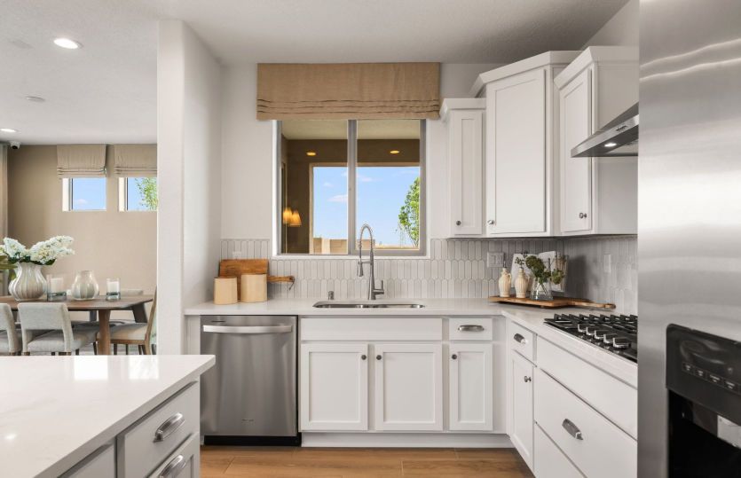 Stainless steel Kitchenaid® appliances including a gas cooktop, vent hood, built-in oven and dishwas