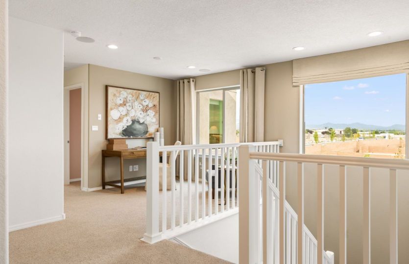 The loft upstairs makes another flexible living area on this home design for a home office, home gym
