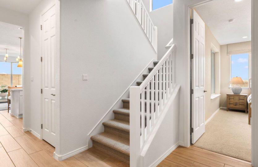 Entry off the two-car garage leads to first floor owner's suite, laundry and into kitchen.