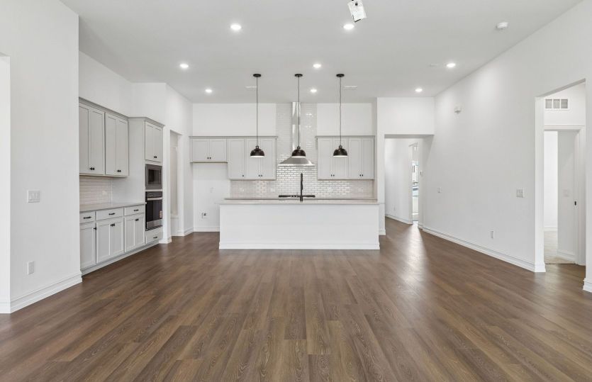 Open concept gathering room with view of kitchen*model representation