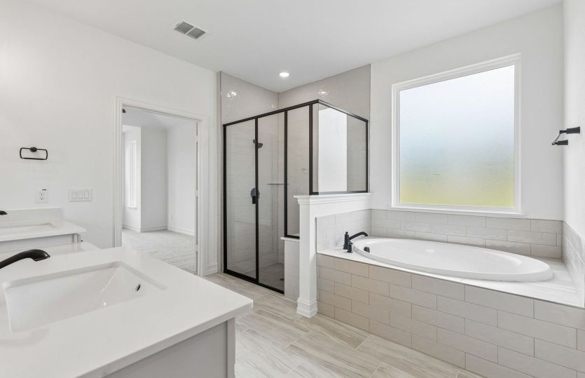 Owners suite with separate tub and shower *model representation