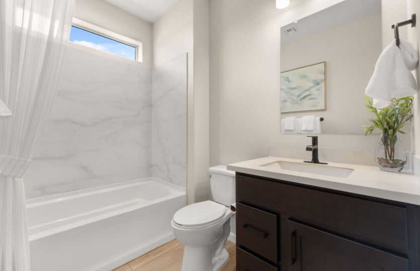 Guest bathroom complete with cultured marble counters and a combined bath tub and shower configurati