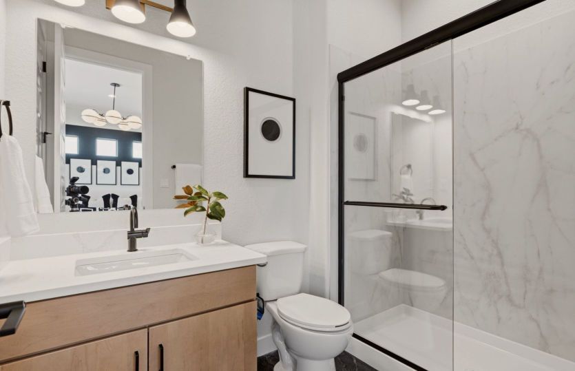Bathroom serving the guest suite complete with a tile shower.