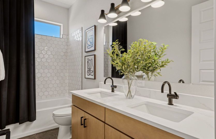 Secondary bathroom serving the bedrooms offers a tub and shower combo and dual sinks.