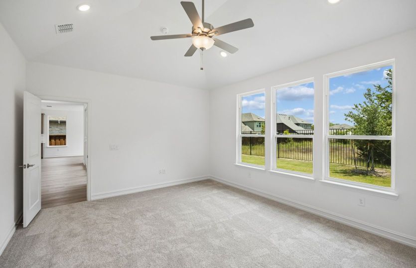 Spacious primary bedroom with large windows