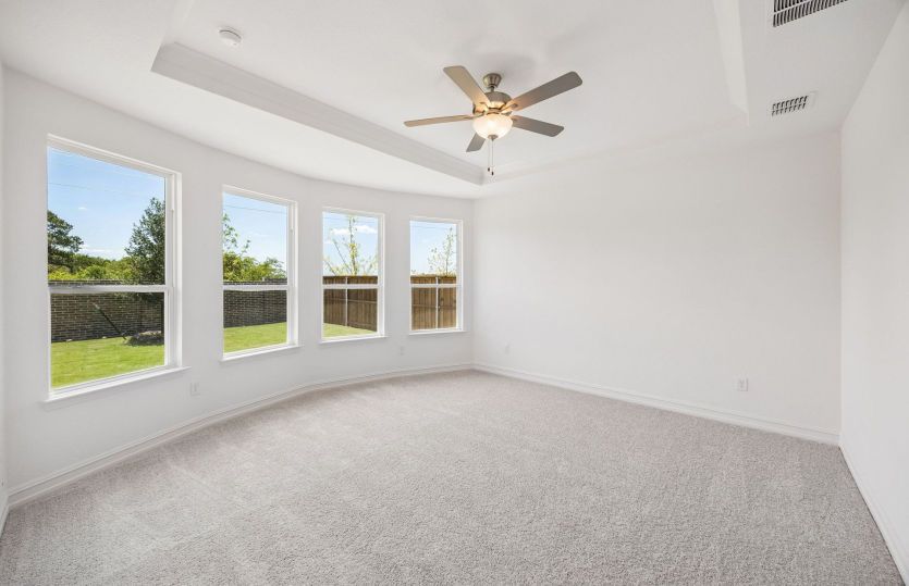 Spacious primary suite with bay windows