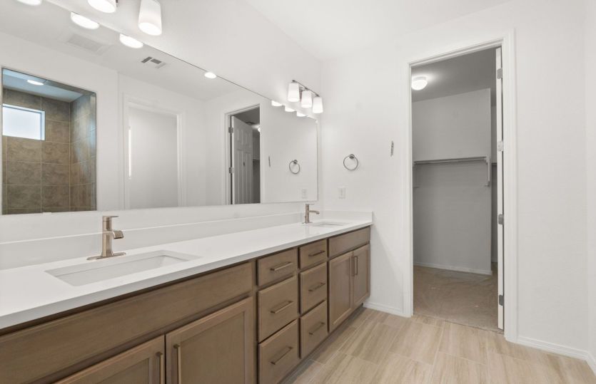 Luxurious owner's bath with dual sinks and ample storage space