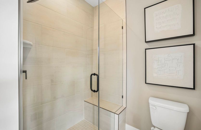 Primary Suite Features a Frameless Glass Shower with Seat