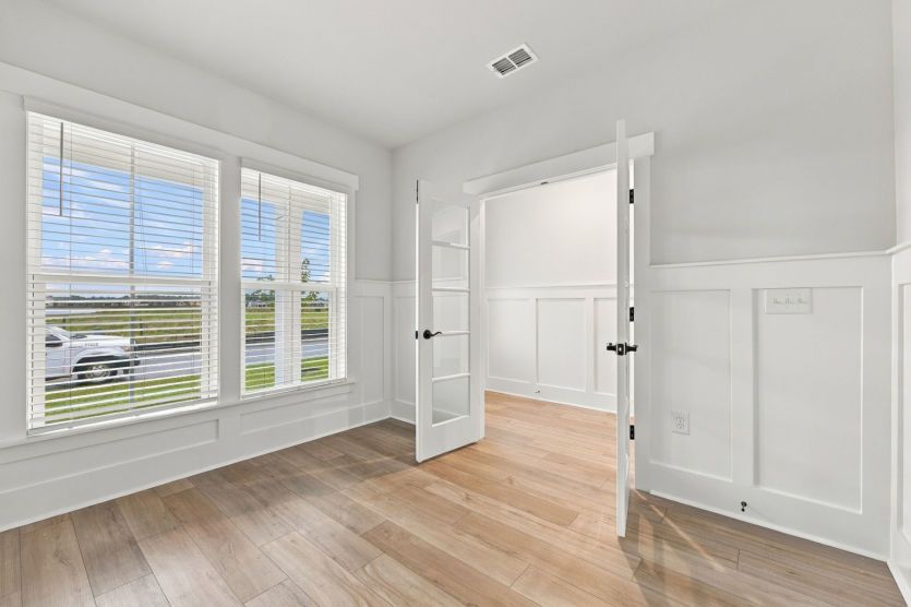 Flex room framed by glass double doors for a polished, open feel.