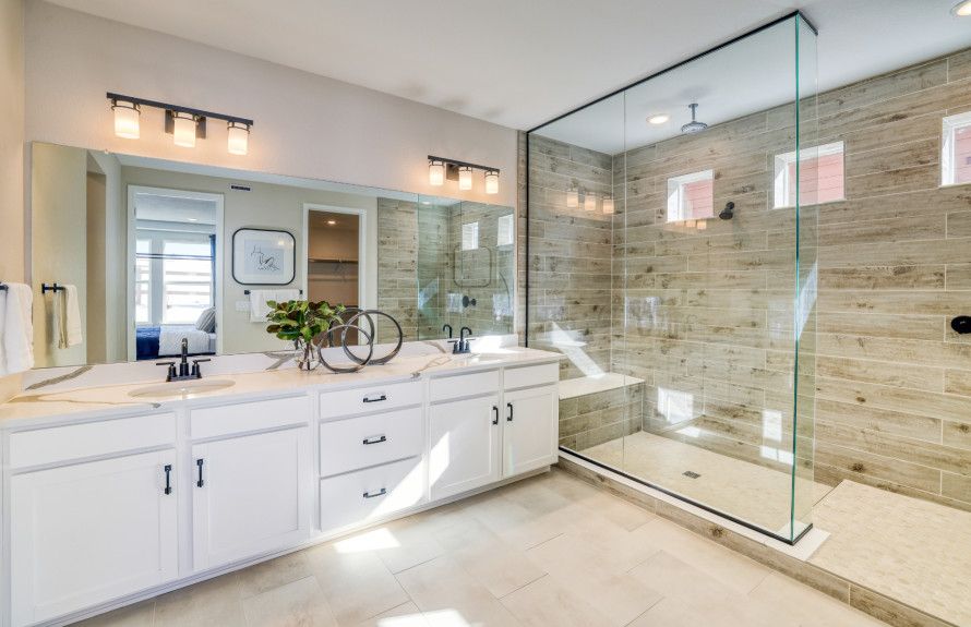 Enter the owner's bath which features a dual sink vanity and a walk-in shower with a stylish glass frame.
