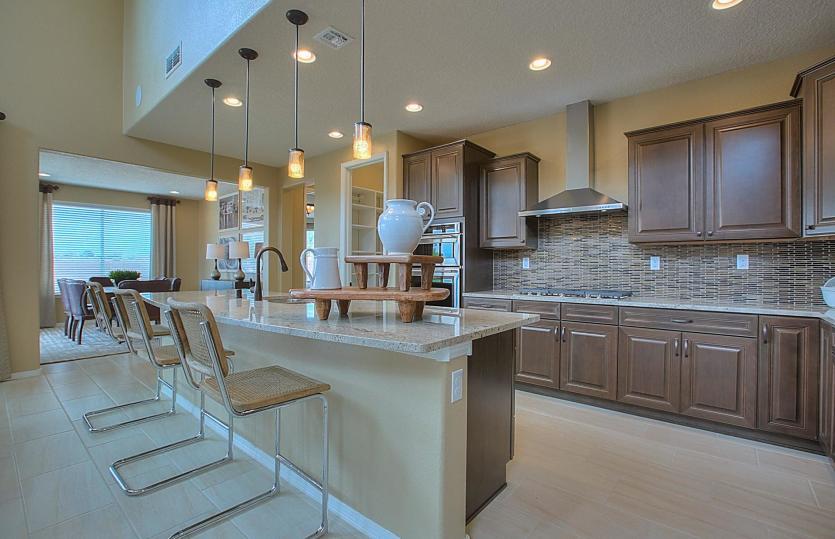Granite island in the kitchen with bronze overhead pendant lighting and comfortable seats for up to