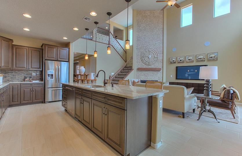 Kitchen overlooks gathering room with large two-story ceilings for the ultimate bright and open feel