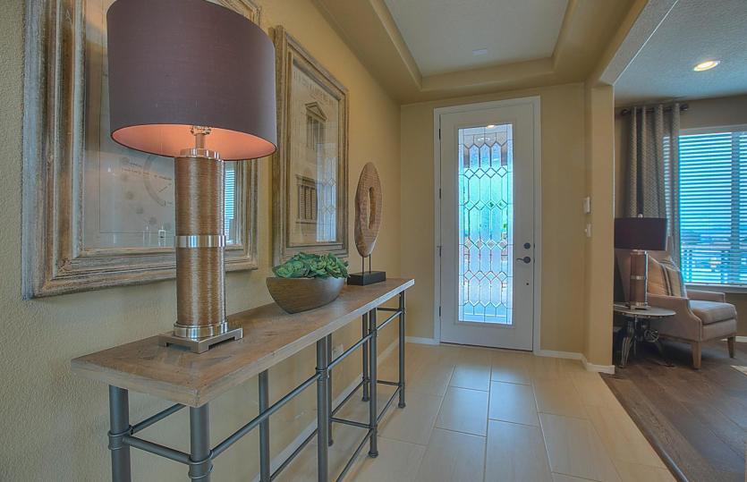 Bright foyer shown with an accented tray ceiling and a decorative glass front door to brighten the e