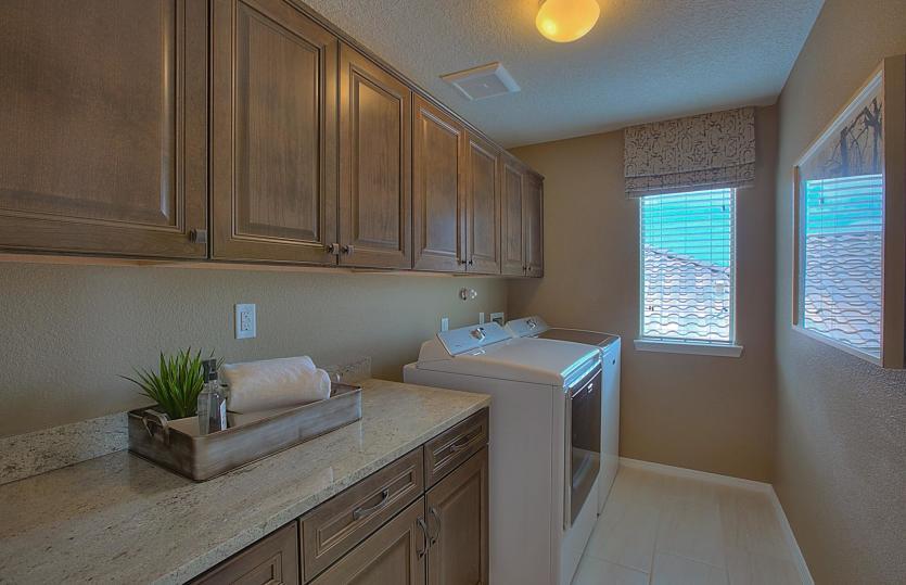 Monza laundry room complete with plenty of cabinet storage, granite countertop and a window for addi