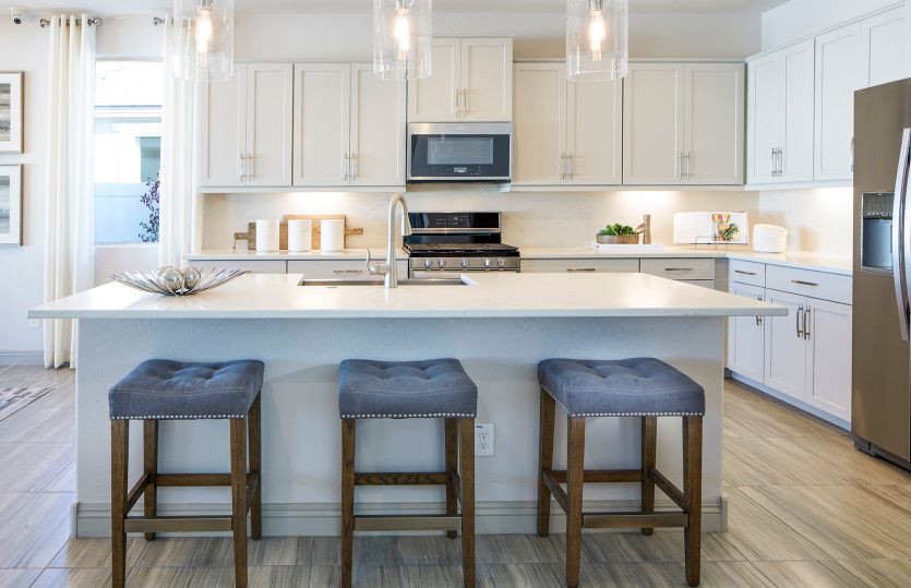 The kitchen island offers additional seating and can be used as a breakfast nook for busy mornings