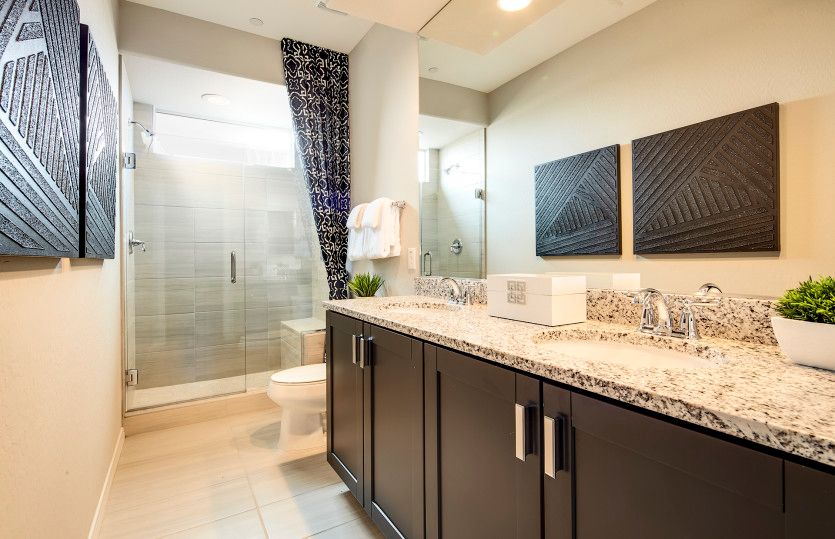 Owner's bathroom with dual vanity sinks and glass walk-in shower