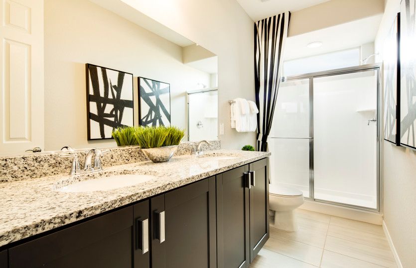 Secondary bathroom with dual sinks and plenty of storage