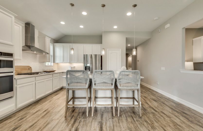 Spacious kitchen with eat-in bartop and pendant lighting over island