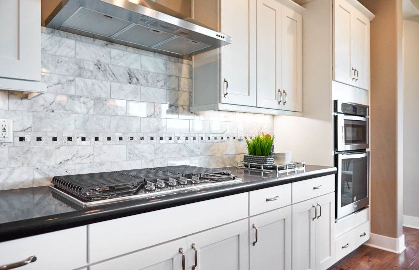 Built-in appliances and upgraded tile backsplash detail in the kitchen.