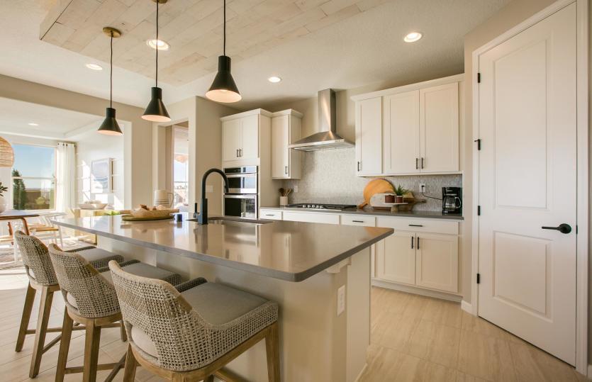 Beautiful brand new kitchen shown with a modern look of white cabinetry, gray countertops, and black
