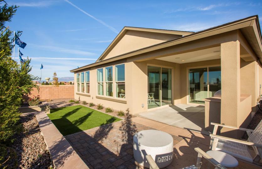 Backyard and covered patio showing a mixture of grassy areas and hard surfaces serving multi-purpose