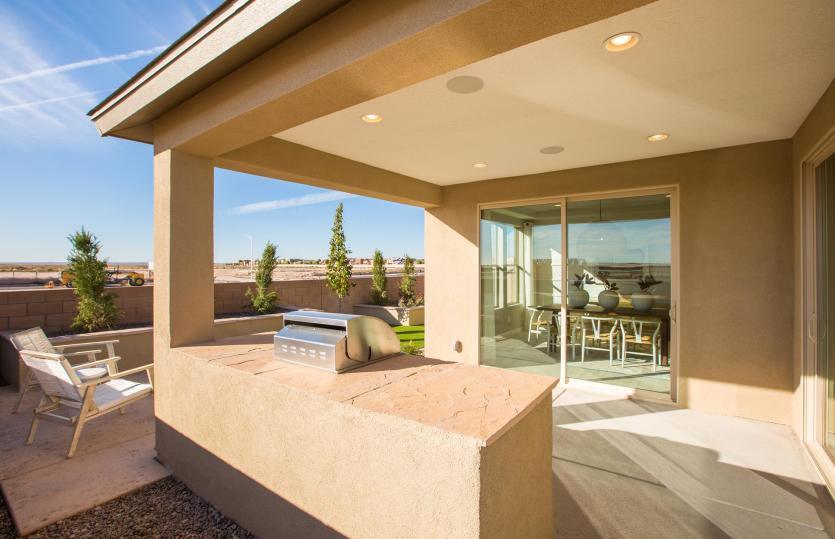 The great-sized covered patio in the backyard with a built-in BBQ grill and plenty of space for seat