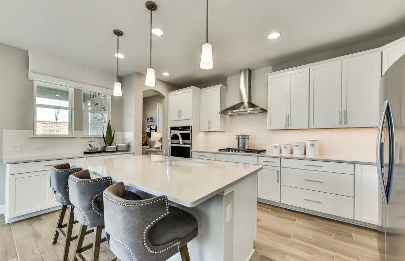 Spacious kitchen with recessed and pendant lighting