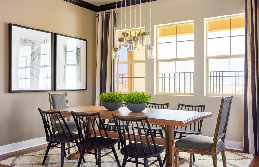 Cafe just off the kitchen is well-lit with a decorative lighting fixture and bright windows.