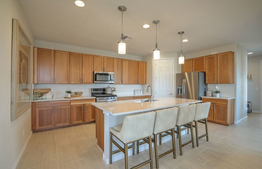 A spacious new kitchen with quartz island, stainless appliances, and a large corner pantry for optim