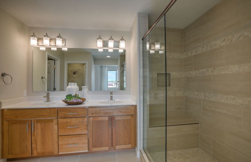 The tile shower in the owner's bath is designed with tile accents and a built-in seat.