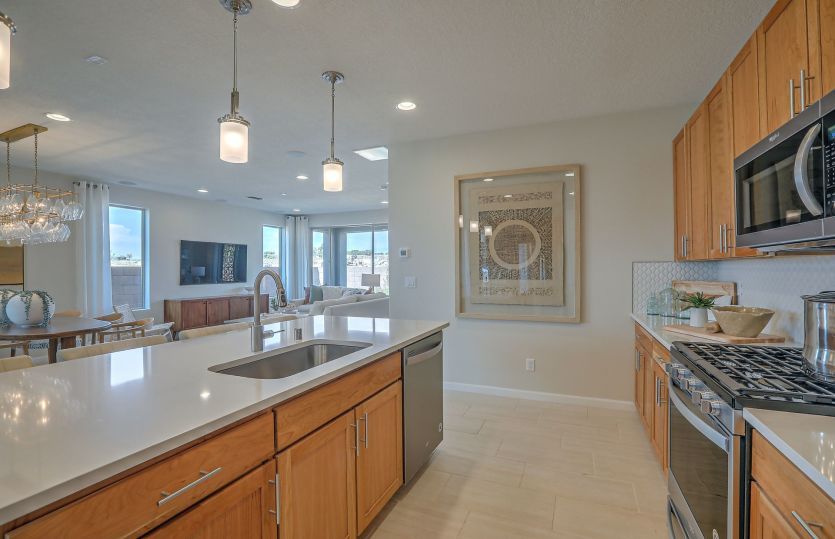 A quartz countertop completes the kitchen island with sink and dishwasher, plus overhead lighting.